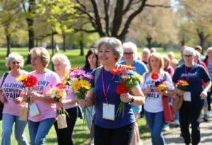 Participants at the Alzheimer’s awareness walk holding colorful flowers.